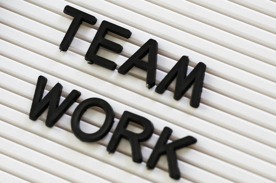 Team Work Steckbuchstaben auf Tafel mit dem Schriftzug "Team Work".