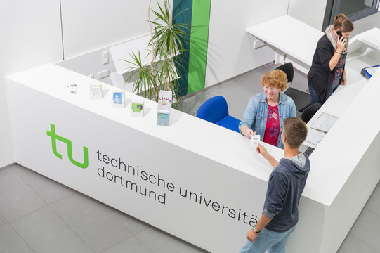 Ein Student gibt seine Wartenummer bei der Studienberatung ab.